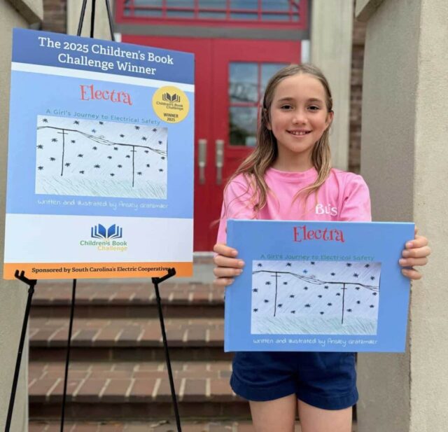 Young girl holds up winning book